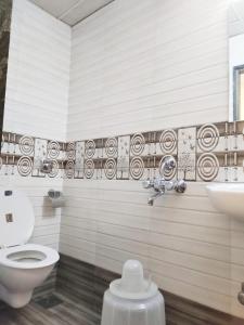 a bathroom with a toilet and a sink at Hotel Golden Galaxy - Santacruz East in Mumbai