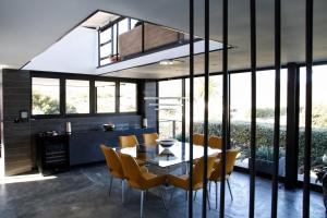 a dining room with a table and yellow chairs at 1 On Royal in Cape Town