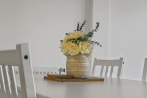 Centrally Located Modern 2Bed 2Bath Apartment في لندن: مزهرية مع الزهور الصفراء موضوعة على طاولة