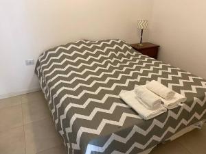 a bed with two towels on it in a room at Departamento Hipólito Irigoyen in Santa Fe