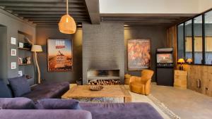 a living room with purple furniture and a fireplace at Villa avec gouvernante et 2 piscines dont une chauffée dans domaine securise in Marrakesh