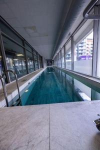 ein leerer Pool in einem Gebäude mit Fenstern in der Unterkunft IGM 2beds Property in London
