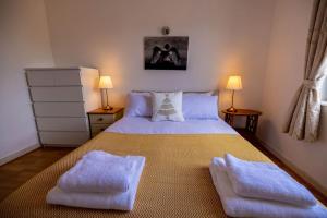 ein Schlafzimmer mit einem Bett mit zwei Handtüchern darauf in der Unterkunft IGM 2beds Property in London