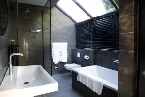 a bathroom with a sink and a tub and a toilet at 1 On Royal in Cape Town +71 photos