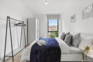 a white living room with a white couch and a window at Centrally Located Modern 2Bed 2Bath Apartment in London