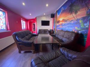 uma sala de estar com sofás, uma mesa e um quadro em Apartamenti em Riga
