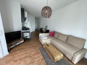 un salon avec un canapé et une télévision dans l'établissement Ferienwohnung Romeike "NewPort", à Bremerhaven