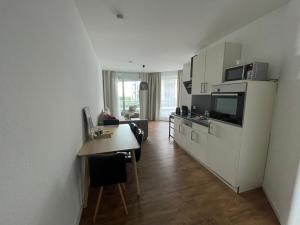 un salon avec une cuisine et une table dans l'établissement Ferienwohnung Romeike "NewPort", à Bremerhaven 10 autres photos