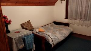 a small bedroom with a bed and a table at Yanks Idila in Zlatibor