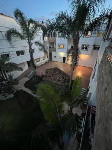 un complexe d'appartements avec des palmiers dans une cour dans l'établissement apartment on the beach, à Harhoura