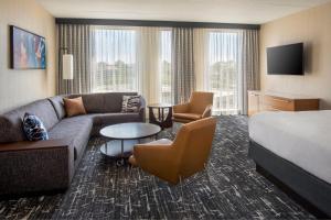 a hotel room with a couch and a bed at Courtyard by Marriott Philadelphia South at The Navy Yard in Philadelphia