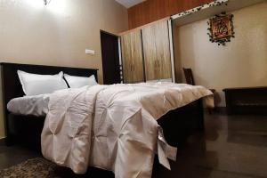 a large bed with a white comforter in a room at Tejovrishananda Luxury Stays in Tirupati