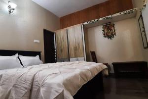 a bedroom with a large bed with a white comforter at Tejovrishananda Luxury Stays in Tirupati