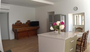 a kitchen with a table and a vase of flowers on a counter at Le jardin des sauges in Dolmayrac
