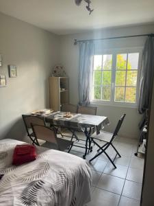 um quarto com uma mesa e cadeiras e uma janela em La rocaille 3 chambres doubles em Fondettes