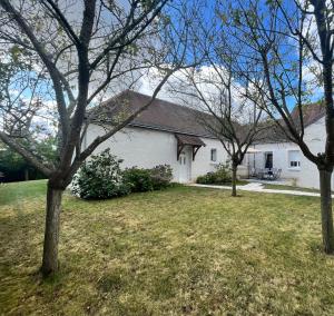 uma casa branca com árvores no quintal em La rocaille 3 chambres doubles em Fondettes