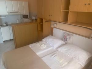 een kleine kamer met een bed met 2 kussens bij Apartments M&M in Rabac