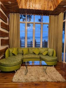a green couch in a living room with windows at One&only homestay in Khao Kho