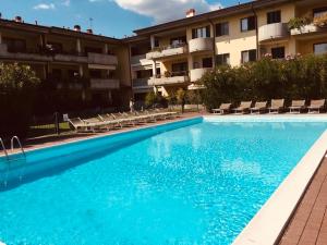 a large blue swimming pool in front of a building at LaMonica.House in Salò