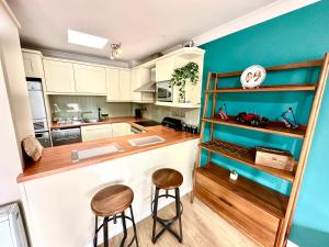 a kitchen with a counter and two stools at Heart of Windsor in Windsor
