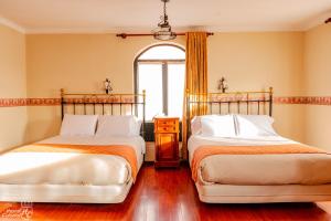 two beds sitting next to each other in a bedroom at Hostal Colonial Potosi in Potosí