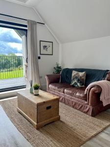 uma sala de estar com um sofá e uma mesa de centro em The Loft Studio apartment - above detached new build garage em Llanymynech