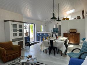 ein Wohnzimmer und eine Küche mit einem Tisch und Stühlen in der Unterkunft LE CLOS DE FLO 17 in Saint-Rogatien
