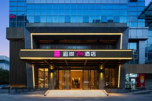 a building with a sign on the front of it at ECHARM Plus Hotel - Hangzhou Binjiang Starlight Avenue in Hangzhou