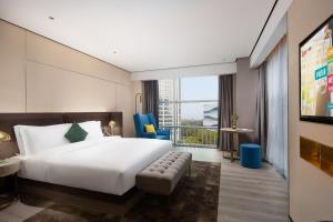 a hotel room with a bed and a large window at ECHARM Plus Hotel - Hangzhou Binjiang Starlight Avenue in Hangzhou