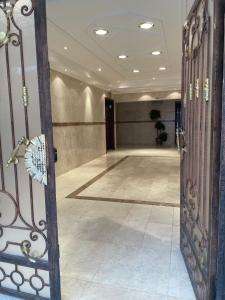 un corridoio con una grande stanza con pavimento piastrellato di Taibah Apartment a Medina