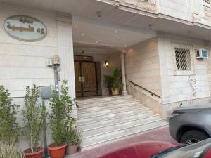 a front door of a house with potted plants at Taibah Apartment in Al Madinah