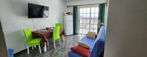 sala de estar con mesa, sillas y TV en Apartamentos América, en Valle Gran Rey