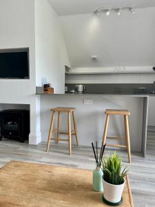 Sala de estar con 2 taburetes de madera y barra en The Loft Studio apartment - above detached new build garage en Llanymynech