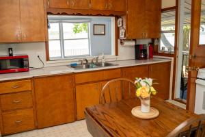 a kitchen with a table with a vase of flowers on it at Paradise Cottage C2 in Greenville