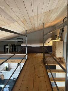 a loft bed with a wooden ceiling in a room at Lillahuset i Helsingborg! in Helsingborg