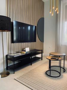 uma sala de estar com uma televisão de ecrã plano na parede em Rosetta Suite em Novi Vinodolski