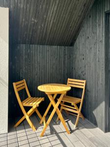 een houten tafel en twee stoelen naast een houten muur bij The Loft Studio apartment - above detached new build garage in Llanymynech