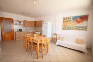 a kitchen with a table and chairs and a refrigerator at Incantevole villa sul mare in Torre San Giovanni Ugento