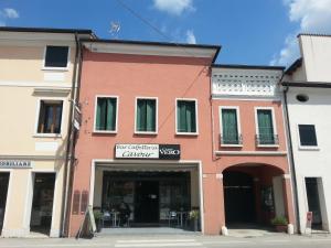 a red building with a store in a street at Locanda Trattoria Caffè Cavour in Cittadella