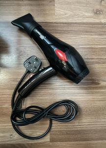 a black hair dryer on top of a wooden table at Modern Style Village House in Kuching +16 photos