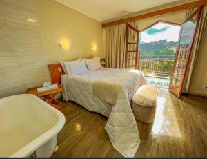 a hotel room with a bed and a bath tub at Hotel Nacional Inn Campos do Jordão in Campos do Jordão