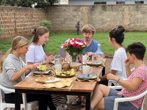 a group of people sitting around a wooden table at Goodtimewithfar House in Moshi +54 photos