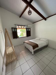 1 dormitorio con cama y ventana en Casa Tropical Arraial D' Ajuda, en Arraial d'Ajuda