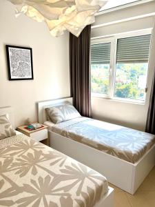 1 dormitorio con 2 camas y ventana en Sandy Shores Residence en Shëngjin
