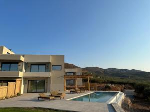 a house with a swimming pool in front of it at Nusa Retreat - Seaview luxury residences in Kissamos