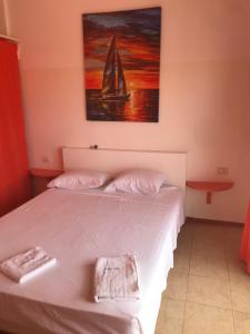a bedroom with a bed with a sailboat on it at Maio Relax in Vila do Maio