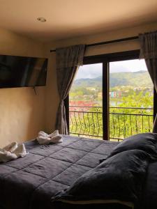 a bedroom with a bed and a large window at Lake View Hostel in Guatapé