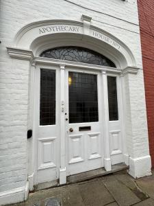 une porte blanche d'un bâtiment avec l'entrée d'une maison d'urgence nord dans l'établissement The Brontë Wing at The Apothecary Rye, à Rye