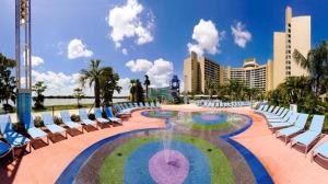 a pool with chairs and a fountain in front of a resort at Bay Lake Tower at Disney's Contemporary Resort in Orlando