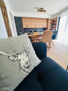 a pillow with a deer head on it sitting on a couch at Family 2 bedroom Ski&Bike Apartment with Terrase in Janske Lazne